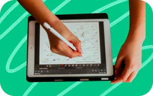 Deux mains esquissent une piste créative sur une tablette graphique