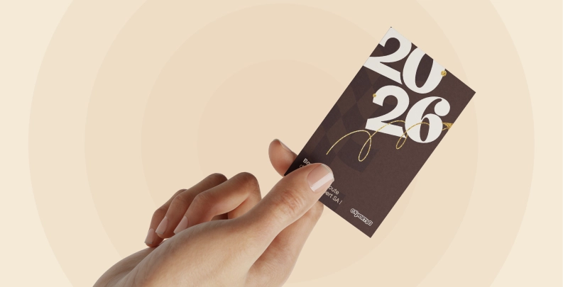 Main tenant une carte de vœux élégante avec l’inscription 2026, sur fond graphique épuré, illustrant la sobriété et le professionnalisme attendus pour une communication de cabinet comptable.